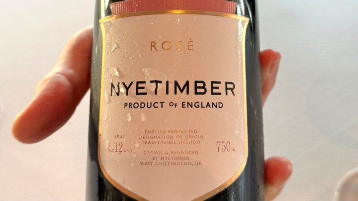 A close-up of a bottle of Nyetimber Rosé sparkling wine, featuring details of the label that states it is a product of England.