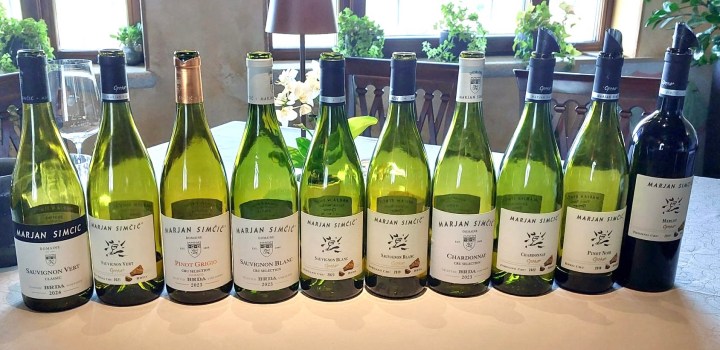 A collection of wine bottles from Marjan Simčič displayed on a table, featuring various white wines such as Sauvignon Vert, Pinot Grigio, and Sauvignon Blanc, along with a red wine.