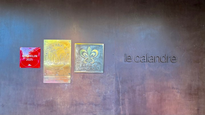 Exterior wall of Le Calandre restaurant featuring its Michelin 2025 star award and recognition plaques.