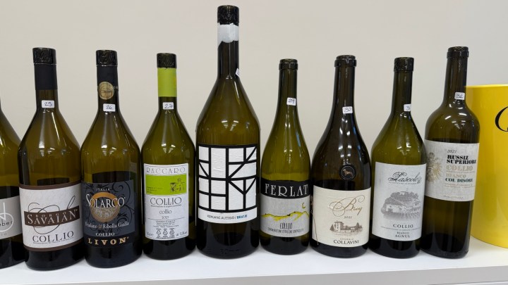 A display of several wine bottles from the Collio region, showcasing various producers and styles, with labels visible for identification.