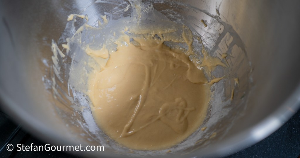 A mixing bowl with a smooth, thick batter for girini pasta, showing remnants of the batter on the sides.