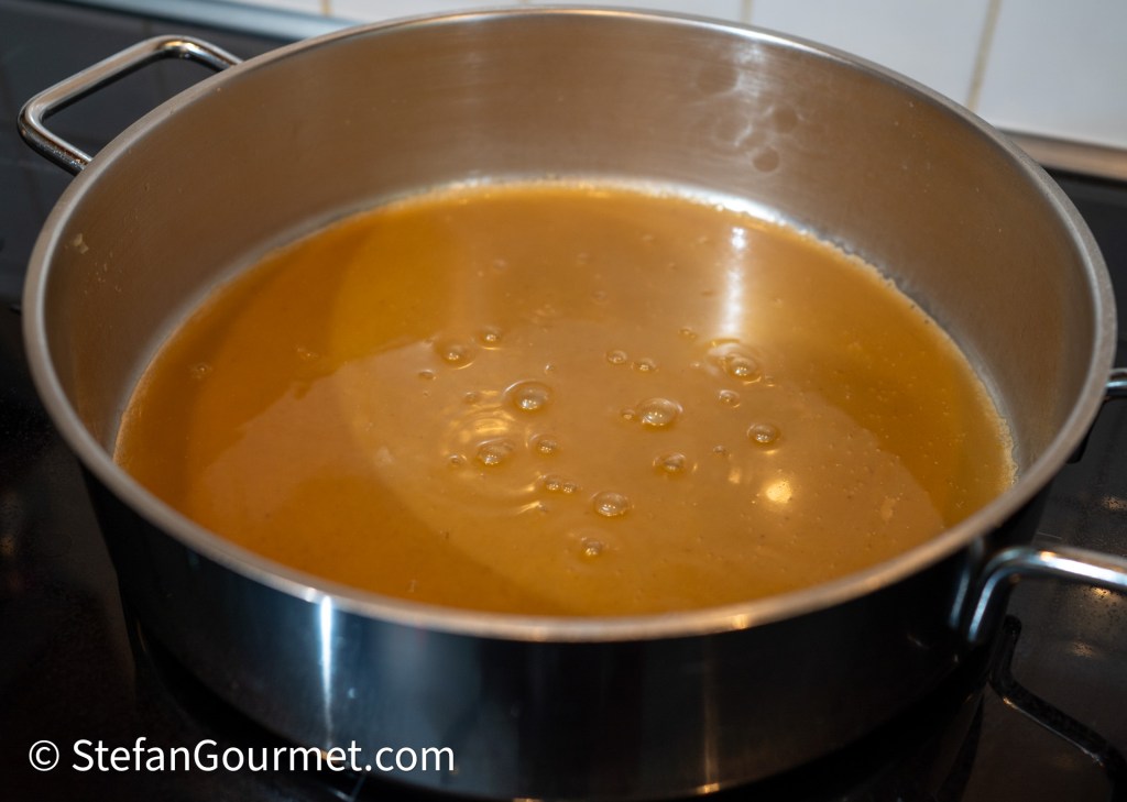 A pot filled with simmering rabbit gravy, bubbling gently on a stove.