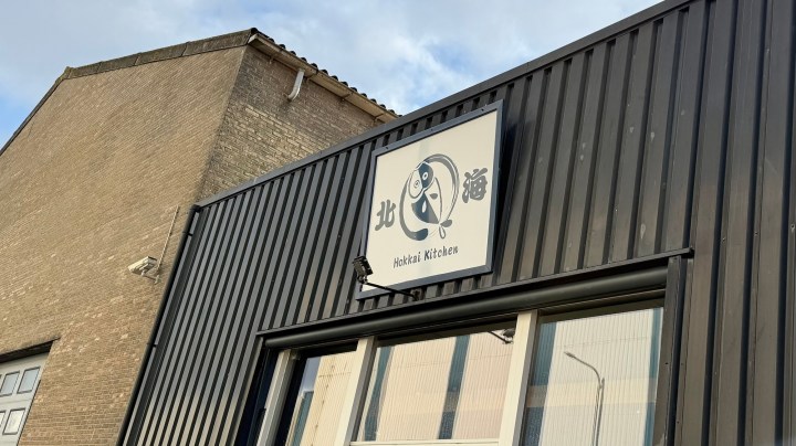 Exterior view of Hokkai Kitchen, a Japanese restaurant with a logo featuring a horse mackerel, located in IJmuiden, Netherlands.