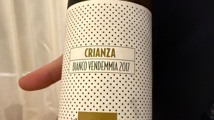 Close-up of a wine bottle label showing 'Crianza Bianco Vendemmia 2017' with a polka dot design.