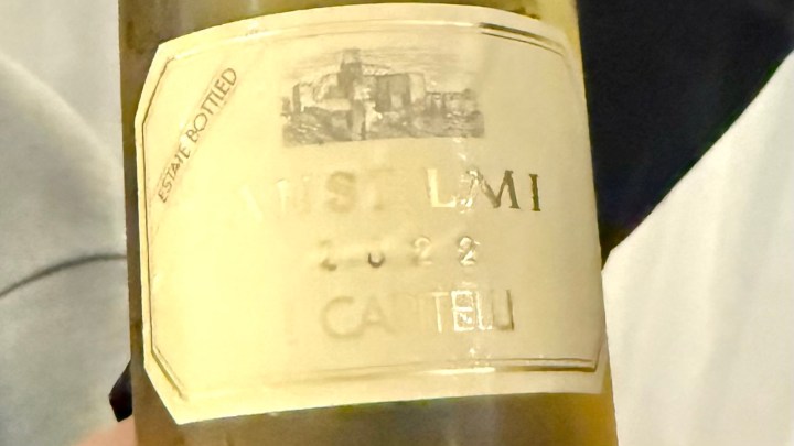 A close-up of a wine bottle labeled 'I Capitelli 2022' with the estate bottling information visible.