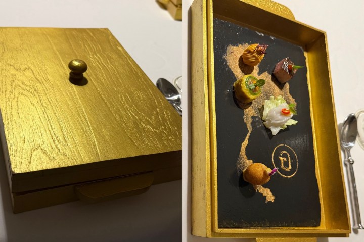 A gold-lacquered box containing colorful amuse-bouches arranged on a map of Thailand, showcasing a variety of miniature Thai dishes.