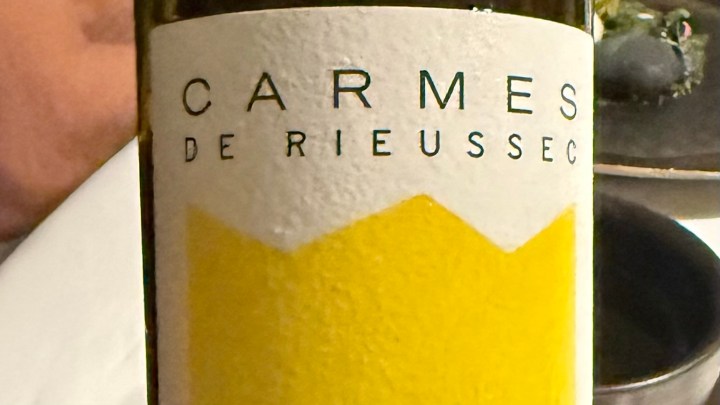 Close-up of a wine bottle labeled 'Carmes de Rieussec' with a yellow and white design.