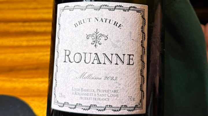 A close-up of a wine bottle label reading 'Rouanne Brut Nature 2023', featuring elegant typography against a textured background.