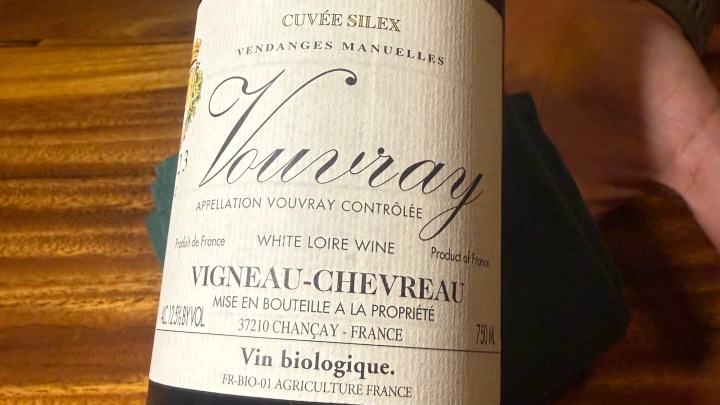 A close-up image of a Vouvray wine bottle label, displaying the text 'Cuvée Silex, Appellation Vouvray Contrôlée, White Loire Wine, Vigneau-Chevreau, Vin biologique' on a wooden surface.