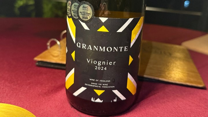 A close-up of a bottle of Granmonte Viognier 2024 wine, featuring a colorful label with geometric designs and text indicating it is a Thai wine from the Khao Yai region.