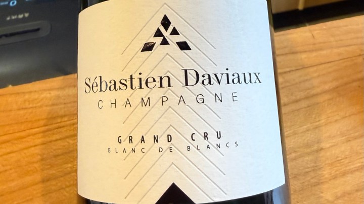 A close-up of a champagne bottle label featuring Sébastien Daviaux, labeled as Grand Cru and Blanc de Blancs.