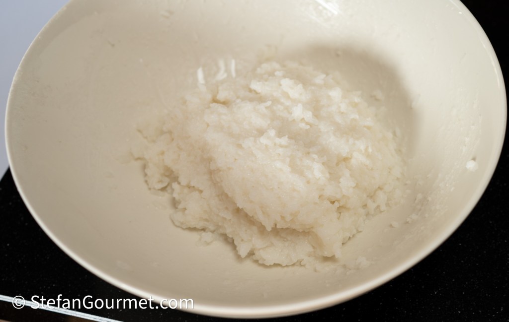 A bowl of sticky white rice or rice-based dish, showing a thick, creamy texture.
