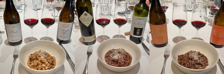 A dining table set with wine glasses filled with red wine, along with three bowls of risotto: one with a light brown dish, another with a darker brown dish, and the last with a rice dish topped with grated cheese.