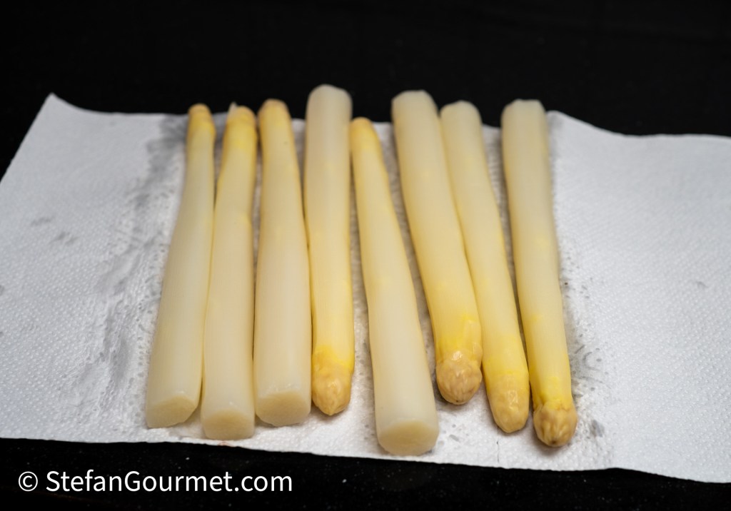 Fresh white asparagus spears arranged on a paper towel.