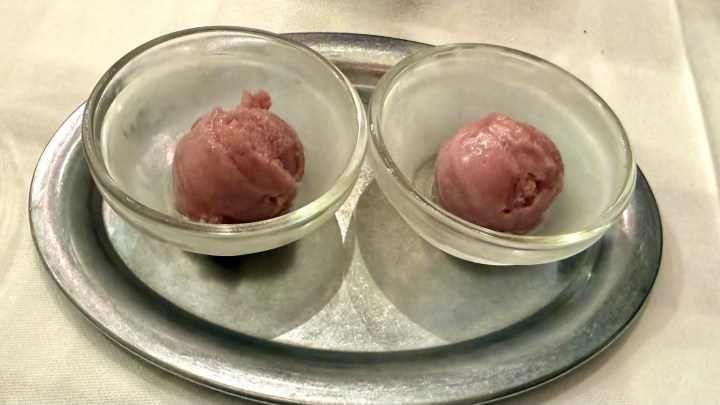 Two scoops of purple sorbet in clear glass bowls on a silver platter.