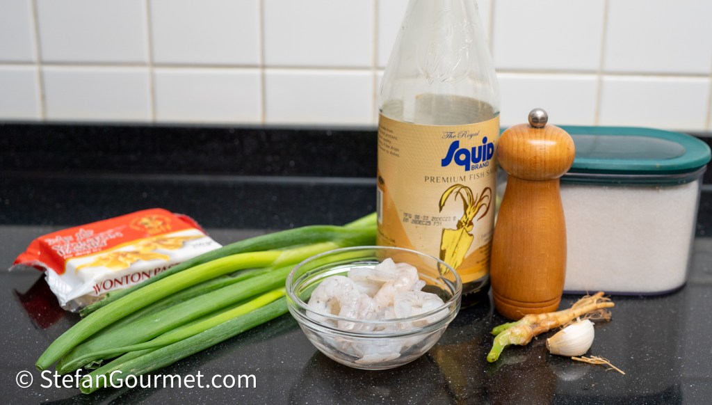 Ingredients for a recipe including wonton wrappers, green onions, shrimp, fish sauce, pepper mill, garlic, ginger, and sugar.