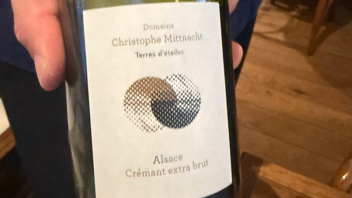 A close-up of a wine bottle label featuring 'Domaine Christophe Mittnacht, Terres d'étoiles' and 'Alsace Crémant extra brut.' The label has a minimalist design with two overlapping circular patterns.