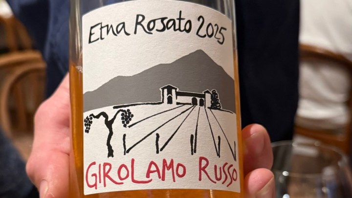 A close-up image of a wine bottle label featuring the name 'Etna Rosato 2025' and 'Girolamo Russo', depicting a vineyard landscape with a mountain outline.