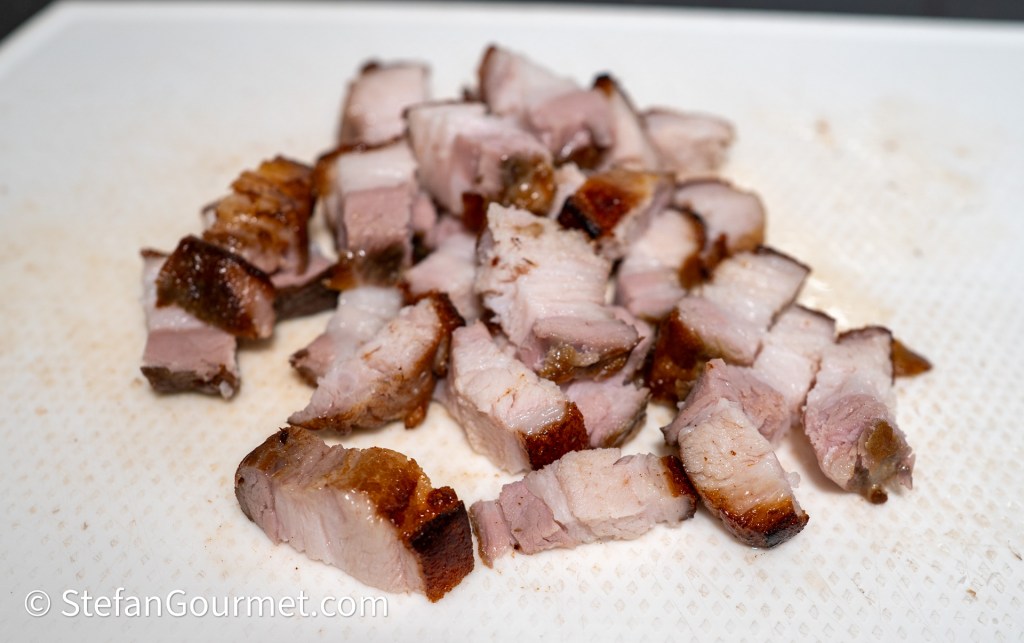 Sliced pieces of roasted pork on a cutting board.