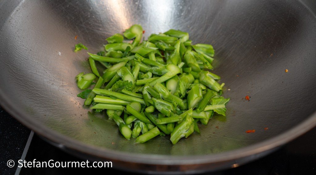Chopped green vegetables in a wok, ready for stir-frying.